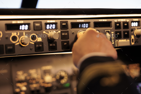Captain pushing buttons to fix altitude level on control panel command