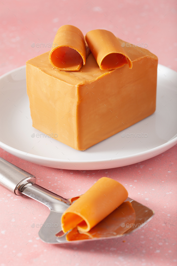 Norwegian brunost traditional brown cheese block and slicer Stock Photo by  duskbabe