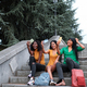 Three friends sitting on a staircase outside having fun taking a selfie each with their smartphones - PhotoDune Item for Sale