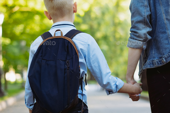 mother and son going to school holding hands Stock Photo by uraneva