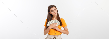 Photo of happy young woman standing isolated over grey background. Looking aside holding money and