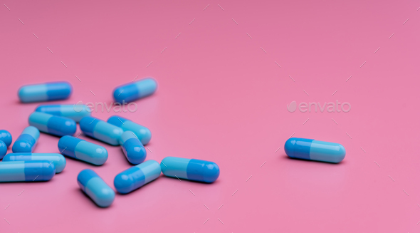 Blue capsule pills on pink background. Prescription drug. Pharmaceutics. Pharmaceutical industry.