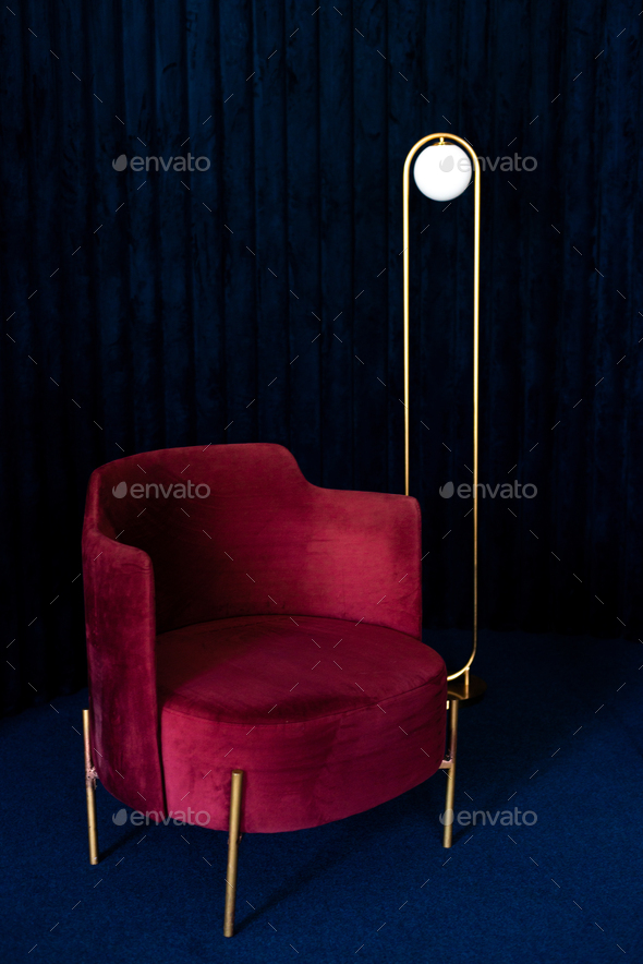A room with a comfortable red velor armchair, a minimalist floor lamp in the living room