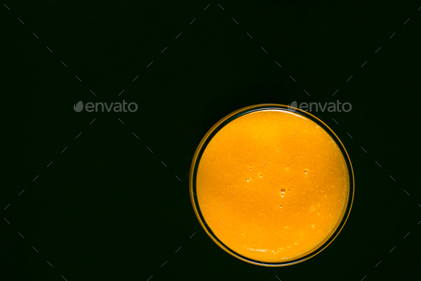 Glass of mango juice on black background. Stock Photo by sandorfotografia