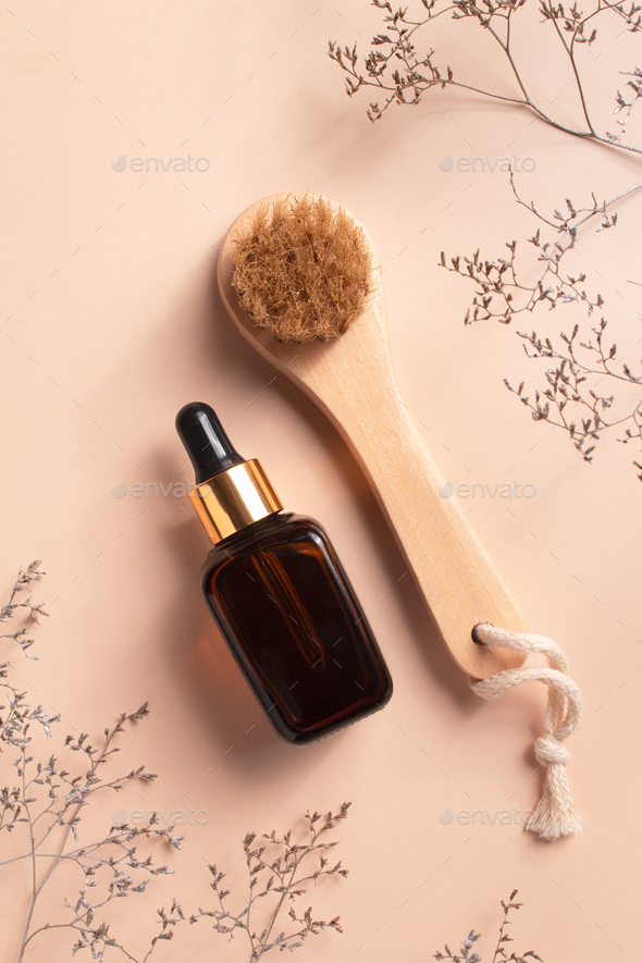 Unbranded serum bottle and anti-cellulite brush for dry body massage.