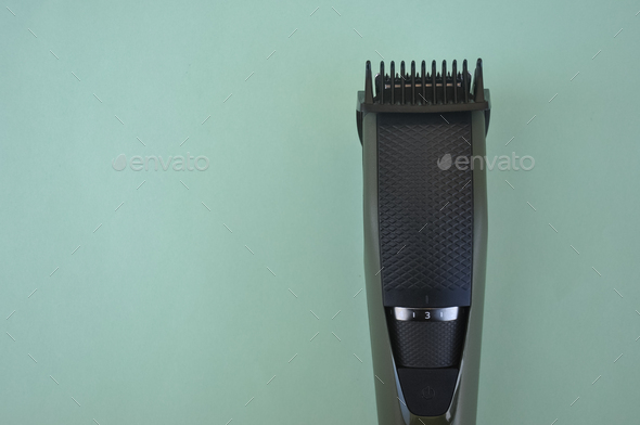 Top angle of front view of beard trimmer with attached comb with negative space