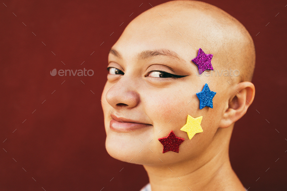 Bald girl wearing stars stickers with red background - Focus on sticker stars