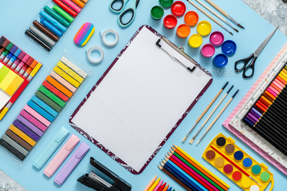 Colorful school supplies placed on blue background with white plain ...