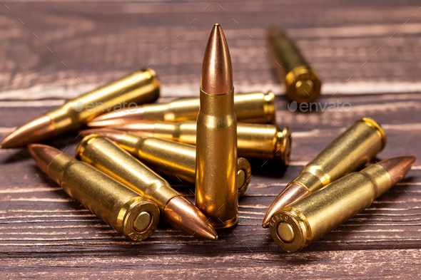 Bullets for Kalashnikov assault rifle on wooden background - Stock Photo - Images