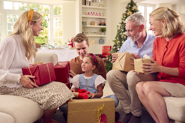 Family Opening Christmas Presents At Home Together Stock Photo