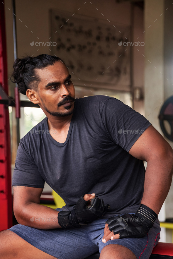 Portrait Sri Lanka bodybuilder man looking away at old gym