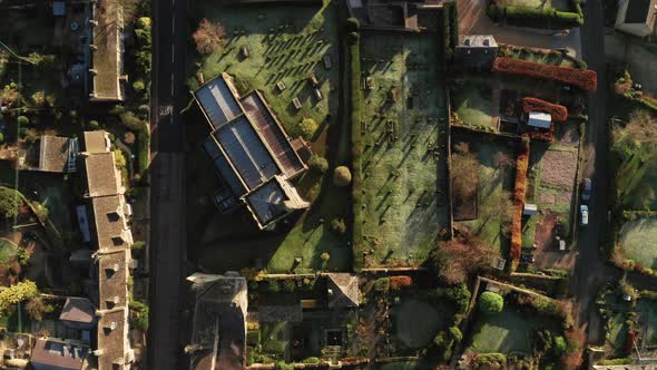 Aerial drone video of a Cotswolds Village, a rural scene in English countryside with houses, propert alt