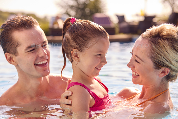 Smiling Family On Summer Holiday Relaxing In Swimming Pool Stock Photo ...