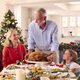 Multi-Generation Family Celebrating Christmas At Home With Grandfather Serving Turkey - PhotoDune Item for Sale