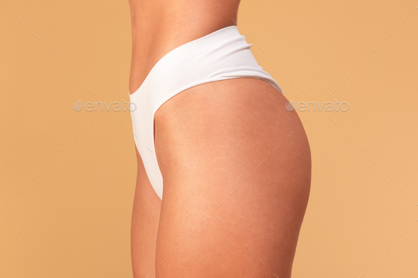 Unrecognizable fit lady posing in white panties, showing smooth sexy hips  without cellulite and Stock Photo by Prostock-studio