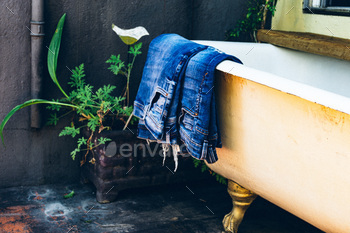 Denim pants on an old vintage bathtub