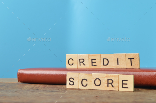 Book and square letters with text CREDIT SCORE.
