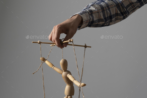 a hand manipulate threaded puppet marionette, human manager master