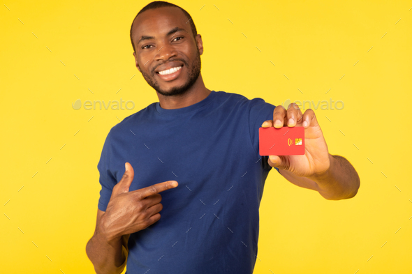 Toothy Black Man Showing Credit Card Advertising Bank, Yellow Background