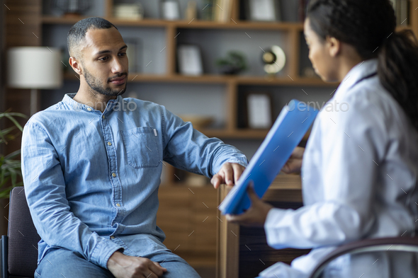 African american lady doctor showing patient treatment plan, having conversation