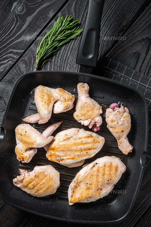 Roasted on a grill skillet chicken meat and chicken parts - drumstick, breast fillet, wing, thigh