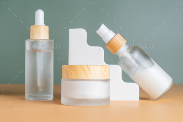 Set of cosmetic products in frosted glass bottles on cocnrete podiums. Skincare unbranded packaging.