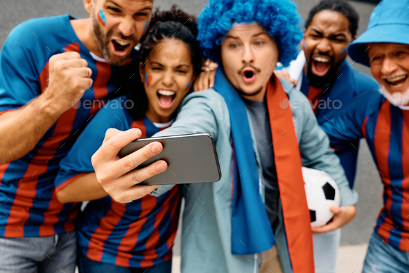 Close up of soccer fans watching live stream of a match on smart phone.