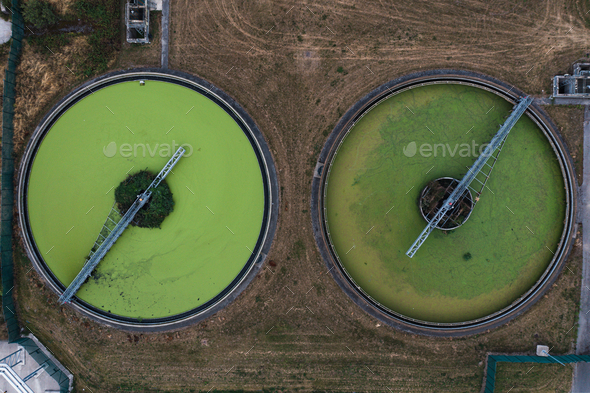Aerial view above waste water treatment plant with green algae