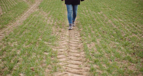 Agriculture - Female Farmer Walking on Agricultural Field alt