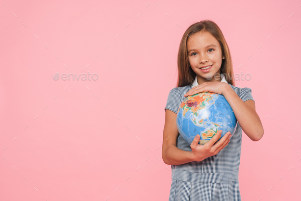 Happy caucasian young schoolgirl preteen girl holding hugging Earth globe for geography lessons