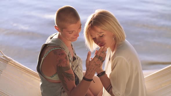 Female couple touching hands.