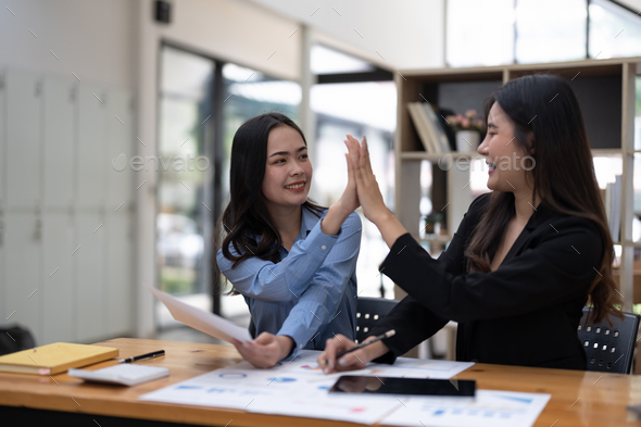 Two people hi five together for thier successful business project in meeting room. Two of business