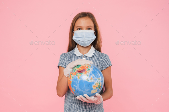 Eco-activist volunteer in mask holding hugging Earth globe in gloves protecting against coronavirus