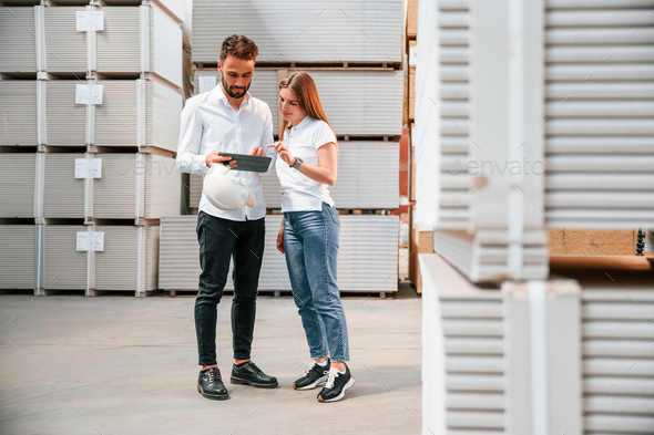 Young manager in formal clothes is working with woman in the warehouse