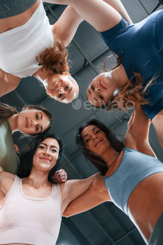View from below. Conception of unity. Group of women practicing fitness in the gym