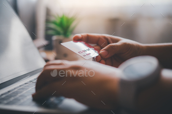 Close up hands holding credit card, typing on the keyboard of laptop, online shopping