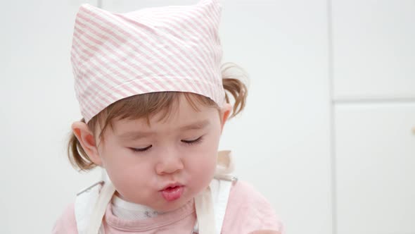 Cute 2-year-old Girl Eating Food In A Toddler Cafe. close up, slow motion alt