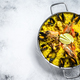 Seafood paella in the fry pan with prawns, shrimps, octopus and mussels.  White background - PhotoDune Item for Sale
