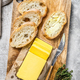 Farm butter and fresh baguette with butter. Gray background.Top view - PhotoDune Item for Sale