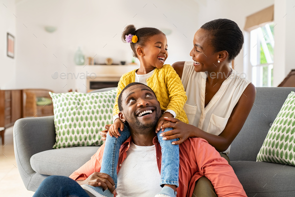 Little black girl playing with parents at home - Stock Photo - Images