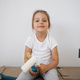 Little blonde cute girl with wall paint roller sitting on the floor - PhotoDune Item for Sale