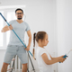 Young family of attractive father and cute little daughter having fun together while repairing room. - PhotoDune Item for Sale
