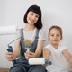 Cheerful woman mother and her little girl daughter sitting on floorwith paint rollers and brushes - PhotoDune Item for Sale
