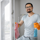 Bearded caucasian man in eyeglasses, sitting on stepladder holding sponge for washing windows - PhotoDune Item for Sale