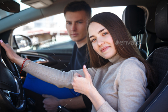 Driving instructor and woman student in examination car.