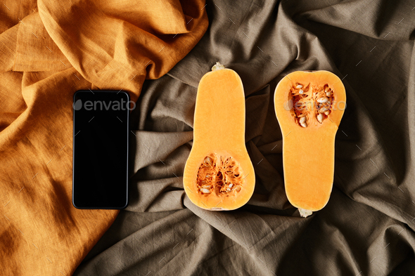 Smartphone and two pieces of pumpkin