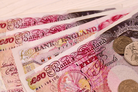 UK money bills and coins close up. Big amount of United Kingdom pounds