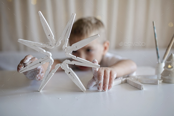 Craft wooden snowflakes from clothespins painted with white color, reusable  DIY New Year ornament Stock Photo by maria_symchychnavr