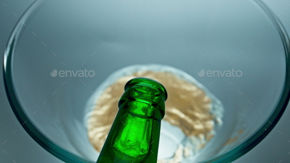 Bottled lager beer pouring vessel closeup. Sparkling cold beverage filling glass