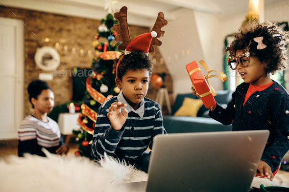 African American kids making video call over laptop on Christmas at home.